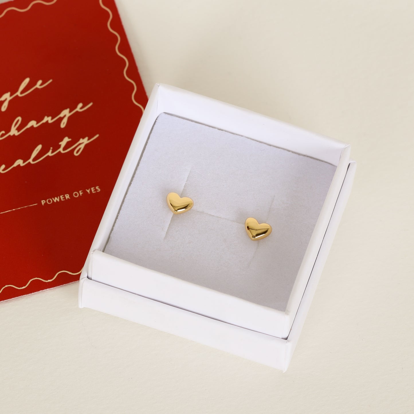 heart shaped gold studs on white box 