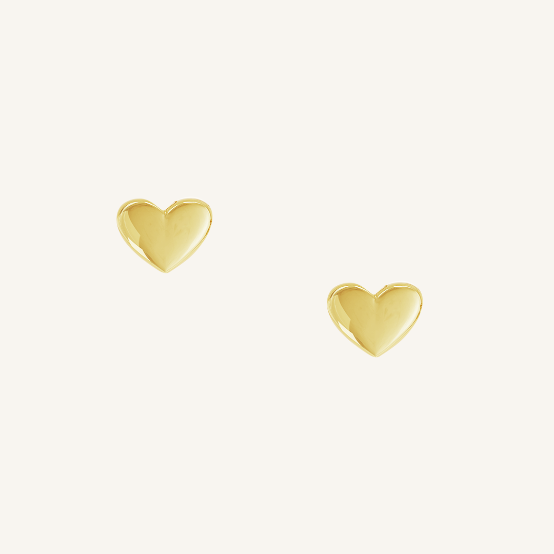 heart shaped gold studs on white background 