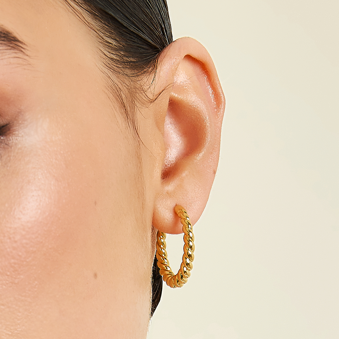 gold hoops inspired by the Louvre's architecture with Marquise cut white cubic zirconias bezel set close up on the ear