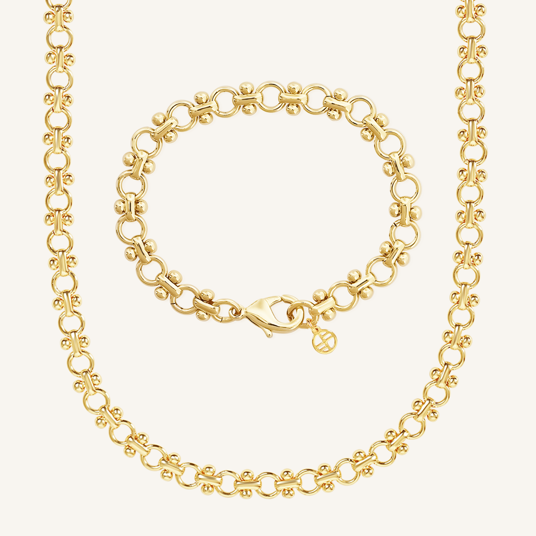 gold chain bracelet and chain necklace set inspired by Eiffel tower on plain white background