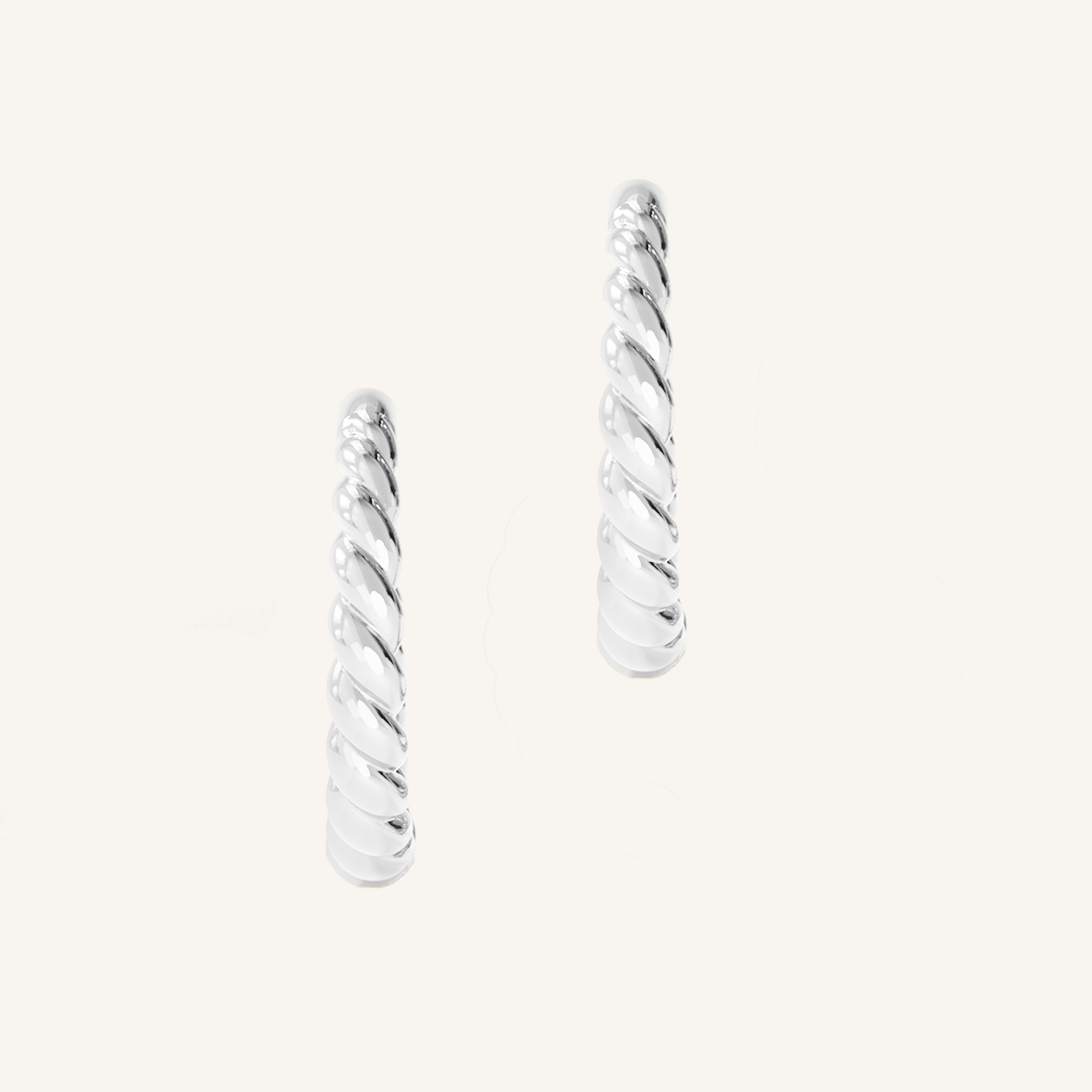 silver hoops inspired by intricate details of the Eiffel tower on white background