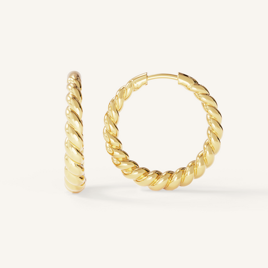 gold hoops inspired by intricate details of the Eiffel tower on white background