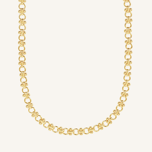 gold chain necklace inspired by Eiffel tower on plain background