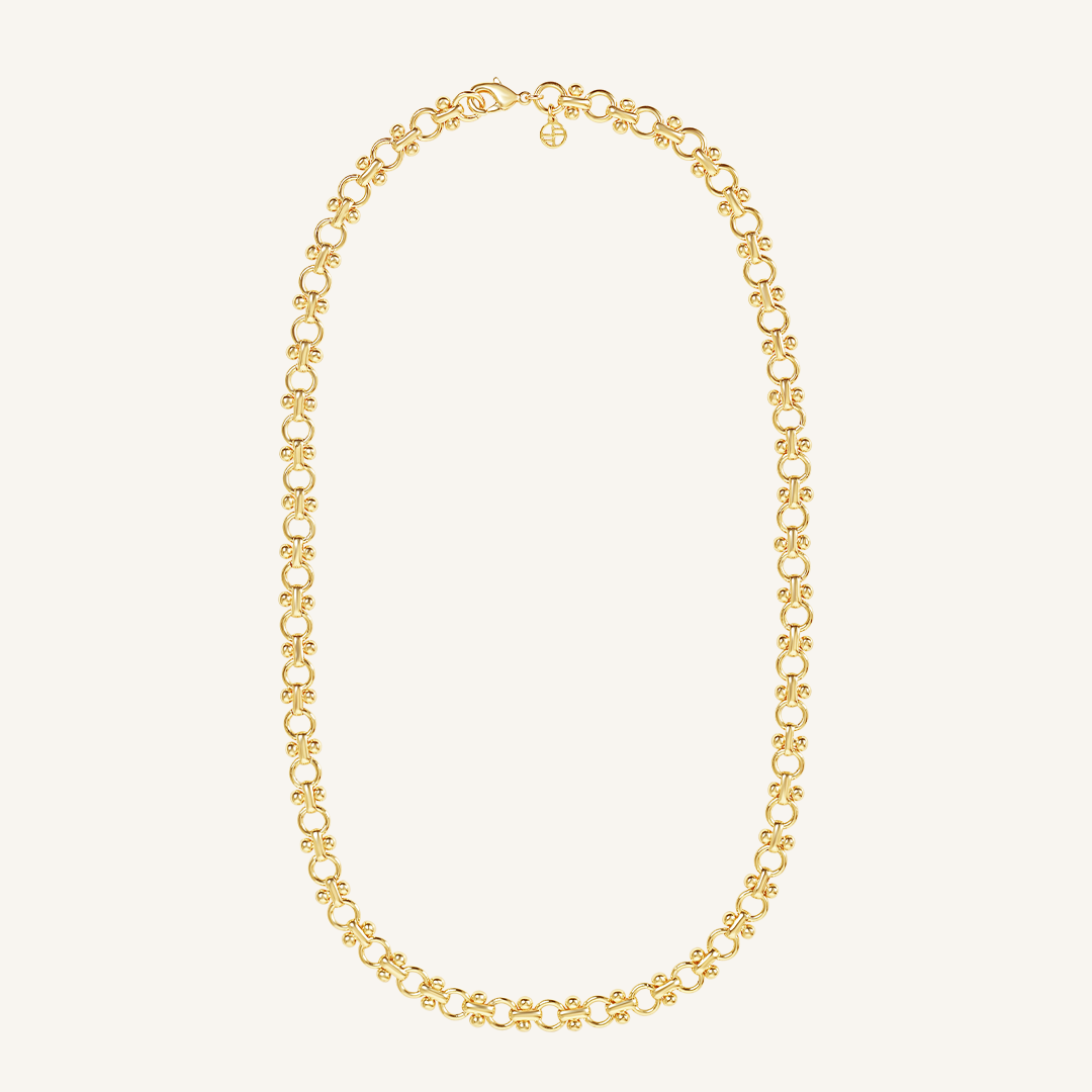 gold chain necklace inspired by Eiffel tower on plain background