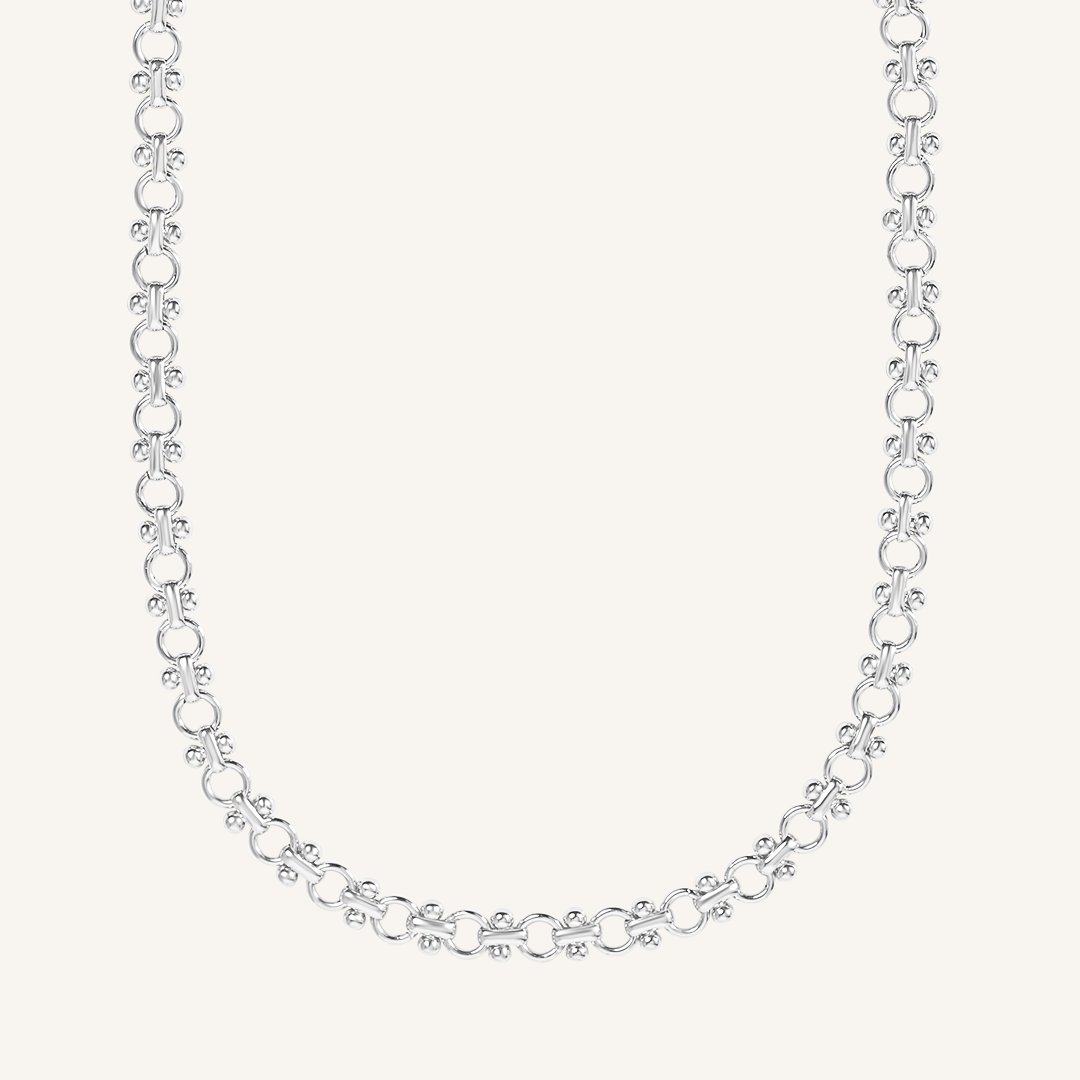 silver chain necklace inspired by Eiffel tower on plain background