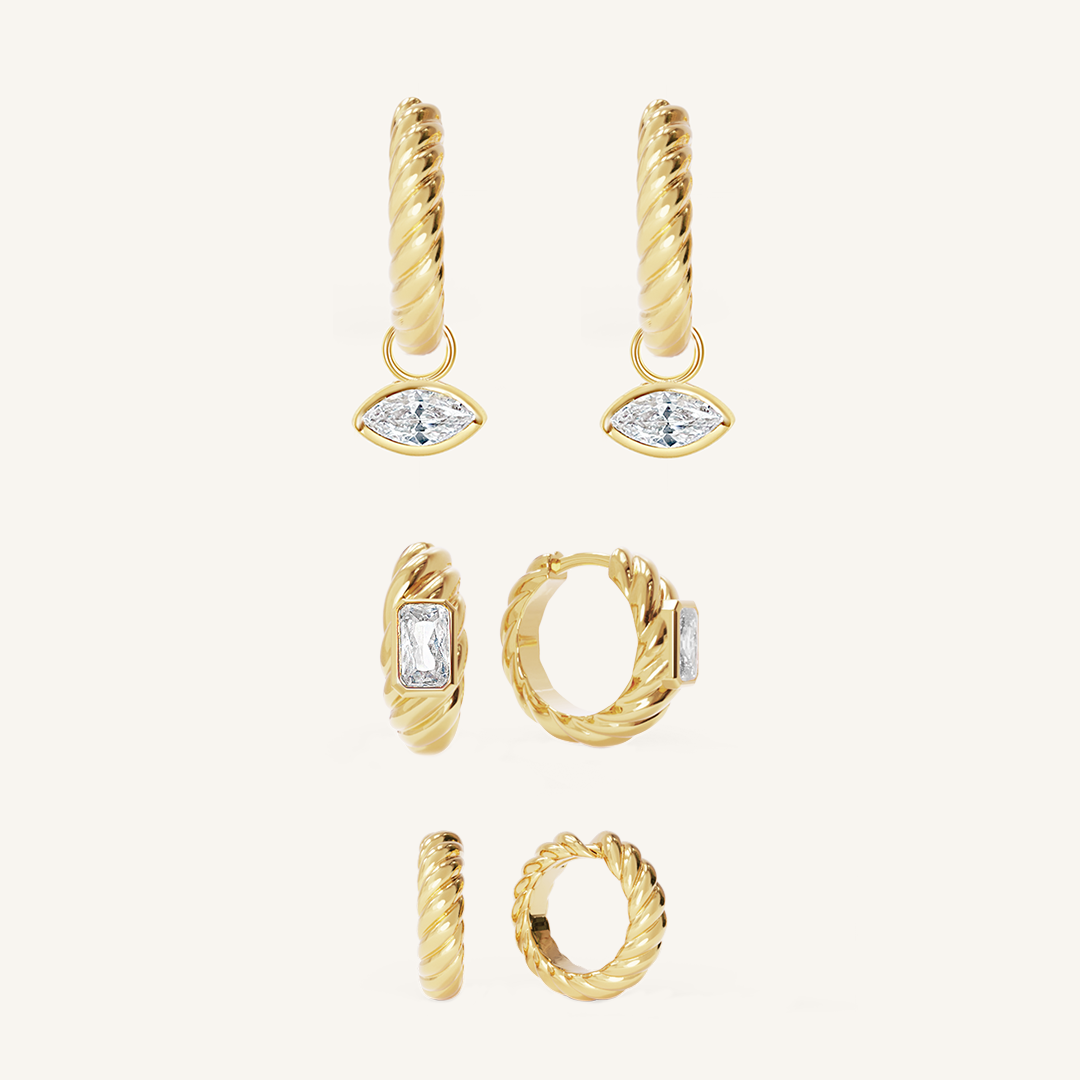 gold delicate huggies with a twist design with gold hoops inspired by the Louvre's architecture with Marquise cut white cubic zirconias with gold hoops inspired by the Louvre's architecture with Marquise cut white cubic zirconias bezel set hoop charms on white background
