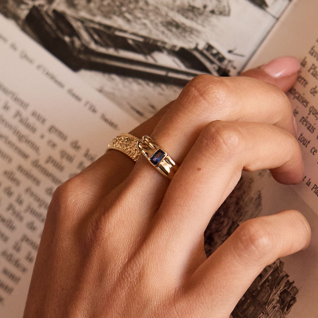 Gold ring with Navy blue cubic zirconia bezel set Inspired by the halls of Versailles close up on finger 