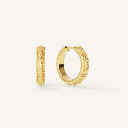 intricately designed gold hoops on white background