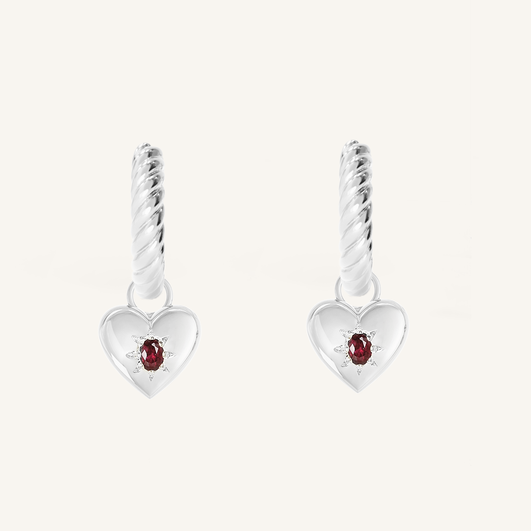 silver hoops with heart charms with deep red oval cubic zirconias on white background