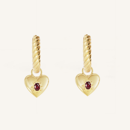 gold hoops with heart charms with deep red oval cubic zirconias on white background