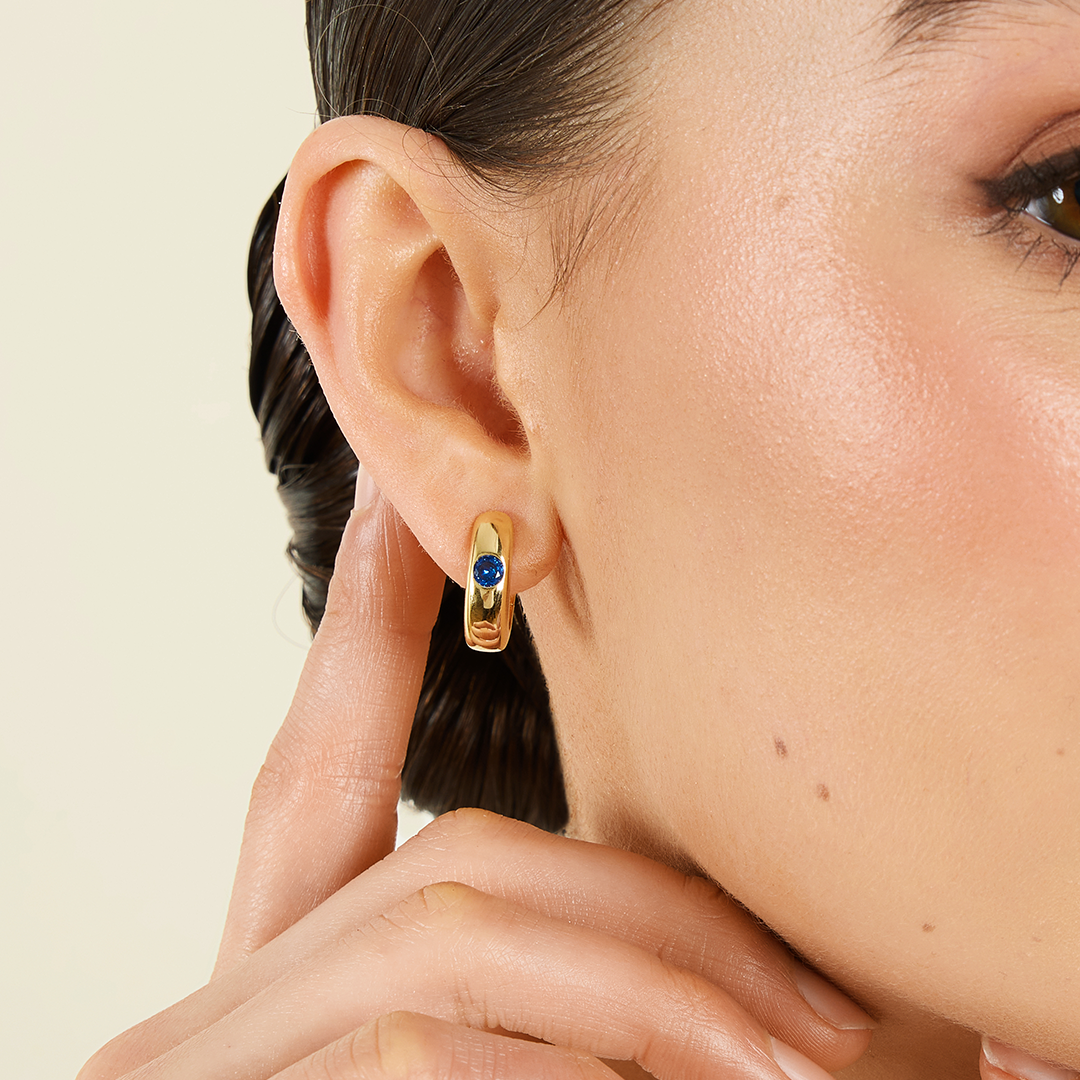 Gold hoops with Navy blue cubic zirconia bezel set Inspired by the halls of Versailles close up on ear