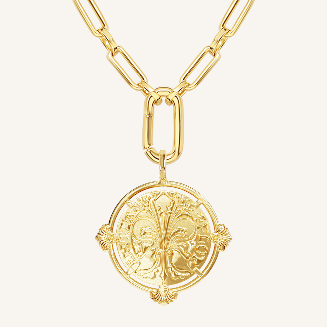 gold pendant featuring intricate patterns inspired by Palace of Versailles on gold link chain on a plain background