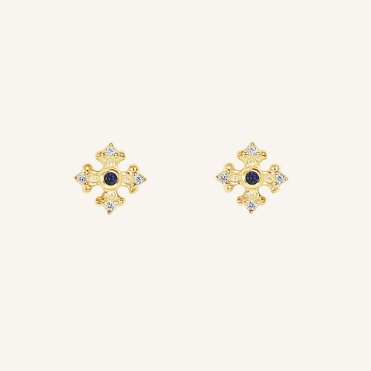 gold studs that features the intricate fleur-de-lis details found in the iconic Palace of Versailles accompanied by the deep blue stone on white background