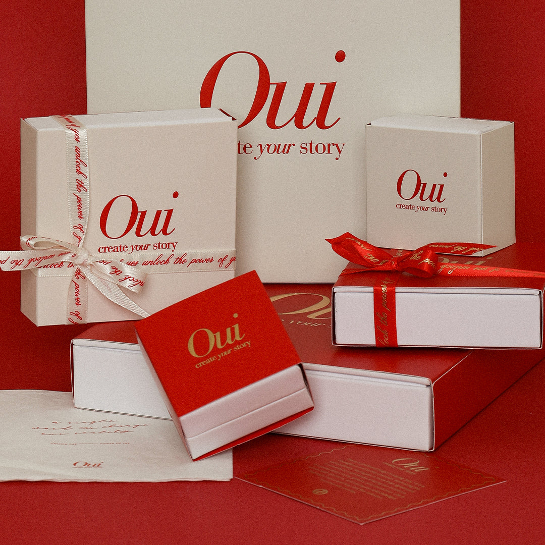 Red, gold and white gift wrapping and ribbon on red background inspired by Paris and the word Oui