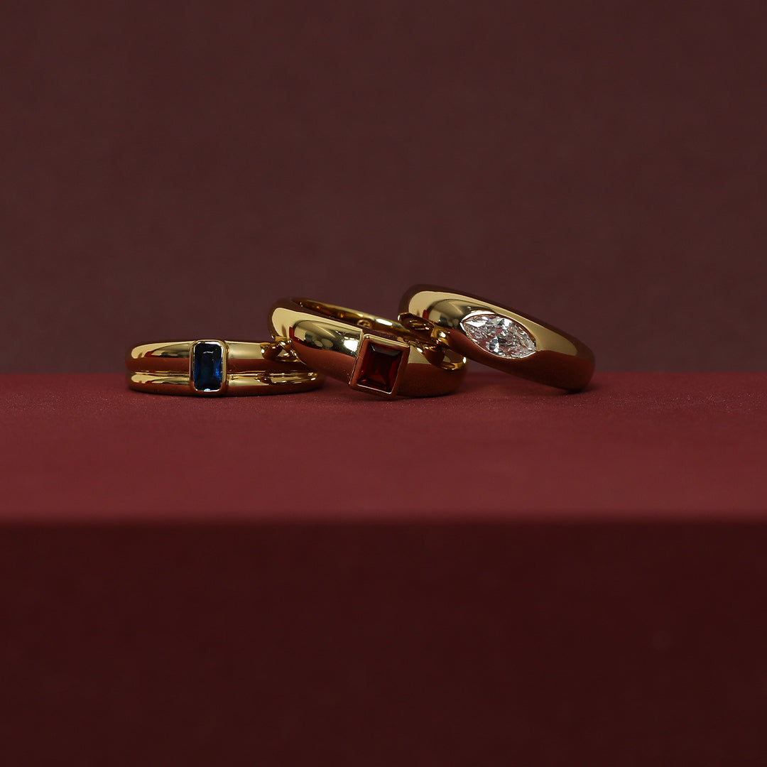 gold rings inspired by the Louvre's architecture with Marquise cut white , blue and red cubic zirconia bezel set on red background